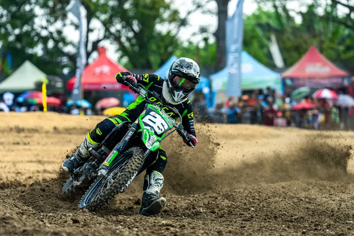 A young rider on track with the paddock and club gazebos behind